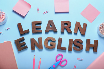 Composition with stationery and text LEARN ENGLISH on color background