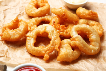 Crispy fried onion rings on table