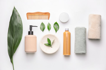 Composition with shampoo, towels and comb on white background