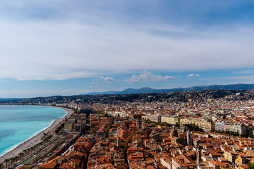Panorama of the old town of Nice, France, the Mediterranean Sea shore and turquoise water, and the distant Alps mountains (Provence / French Riviera / Côte d'Azur)
