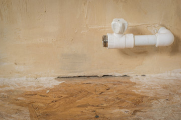 Wet wooden floor under the leaky tap of the heating system in a private house. Accident of the heating system of a private house.