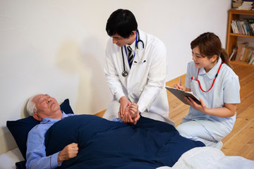 Obraz premium 患者の脈を図る訪問医師