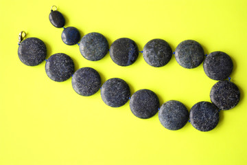 Blue beads made of natural stone on a yellow background. Decoration on the neck of a woman. Jewelry, aquamarine
