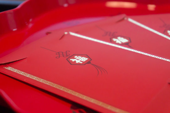 Chinese New Year, Lucky Red Pockets In Red Background And Red Plate Indoor