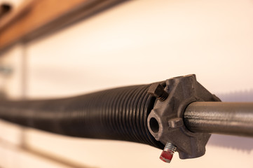 Close up side view of garage door coiled spring