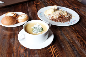 a plate of soup with dill and a plate of buckwheat a good full meal