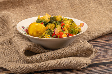 vVegetable salad in a white ceramic bowl on a background of coarse fabric. Close up.egetable salad, village