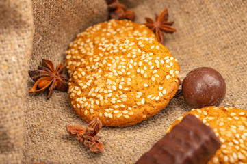 Cookies, star anise and chocolate on a background of coarse fabric. Close up.