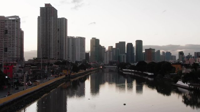 The reflection of Skyscrapers of Metro Manila in the famous Pasig River while sunrise
