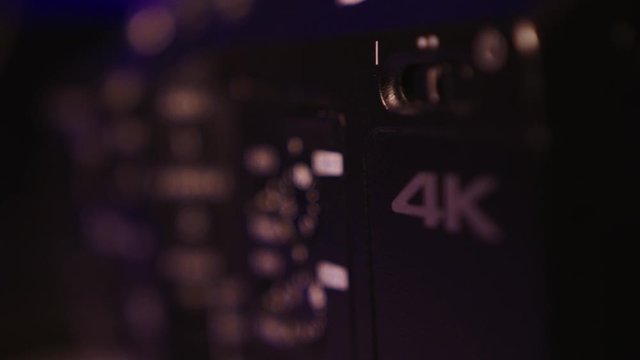 Manual controls of a cinema camera in rack focus, handheld closeup
