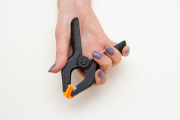 Hand hold plastic studio clip on white background.