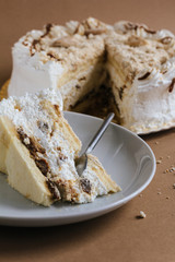 A piece of cake on a plate on the brown background