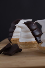 cupcakes in the shape of penguins of meringue with chocolate