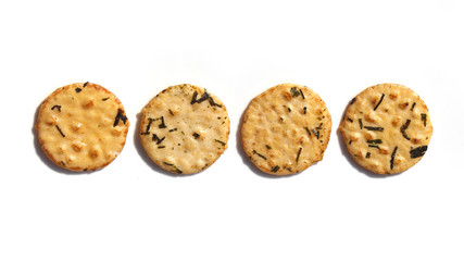 Four round seaweed rice crackers in a row on a white background