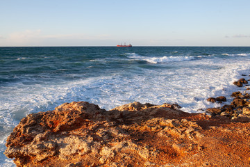 Blue sea in a storm at sunset, sea foam and waves.