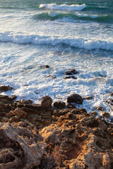 Blue sea in a storm at sunset, sea foam and waves.
