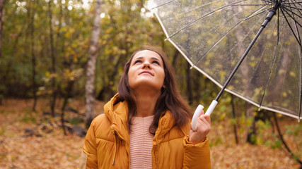 Portrait of a pretty woman holding an umbrella in autumn park