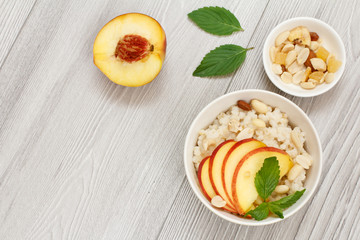 Sorghum salad with nuts and fresh peach on wooden background.