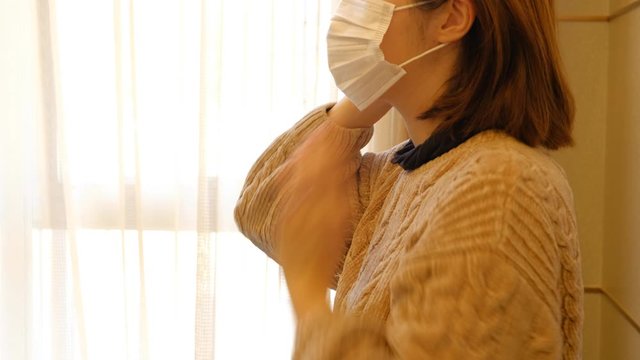 病院の待合でマスクを着ける女性　装着　日本人　