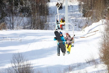 Couple using chairlift at mountain ski resort. Winter vacation