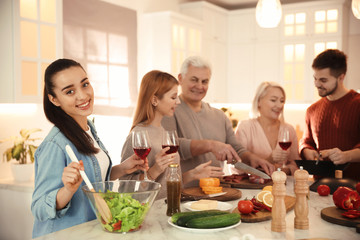 Happy people cooking food together in kitchen