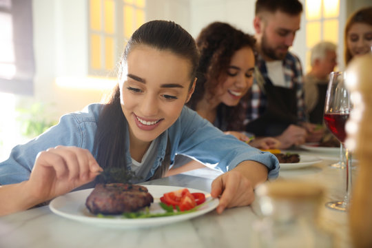 Young Woman Serving Food In Crowded Kitchen. Cooking Class