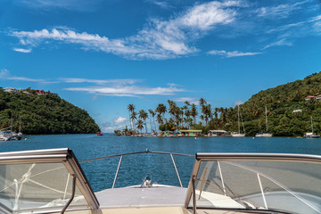 Marigot Bay in St. Lucia. Boats moored in the harbor. Caribbean island with many palm trees and sailing boats. Yacht view. Luxury cruise around islands.