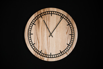 Round eco clock made of wood and epoxy. The subject of interior in your home. Natural handmade tree. Clock isolated on black background.