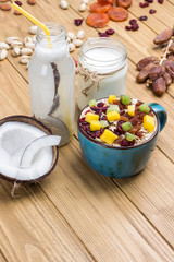 Muesli balanced protein breakfast. Fruits, berries  seeds, nuts, coconut. Coconut beverage and yogurt.
