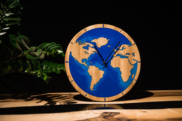 Round eco clock made of wood and epoxy. The subject of interior in your home. Natural handmade tree. Clock on the background.