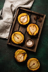 Pears and custard mini tarts on a dark green concrete old table background. Top view.