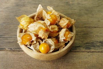 Cape Gooseberry on wooden bowl use for backgroud or wallpaper , selective  focus .