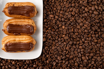 cakes with chocolate icing on coffee. copy space. 