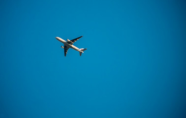 Fototapeta na wymiar A small plane flies in the blue sky