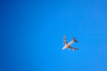 The plane is flying against the blue sky