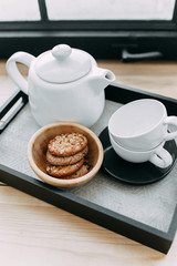 Breakfast, kettle of coffee and tea, tea pairs, oatmeal cookies, tray on the wooden windowsill near the window, service, hotel, restaurant, cafe, delicious, white dishes, good morning