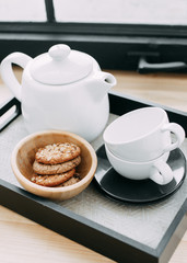 Breakfast, kettle of coffee and tea, tea pairs, oatmeal cookies, tray on the wooden windowsill near the window, service, hotel, restaurant, cafe, delicious, white dishes, good morning