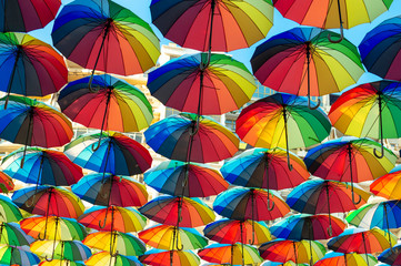 Fototapeta na wymiar Colorful umbrellas background. Colorful umbrellas in the sky. Street decoration. Selective focus