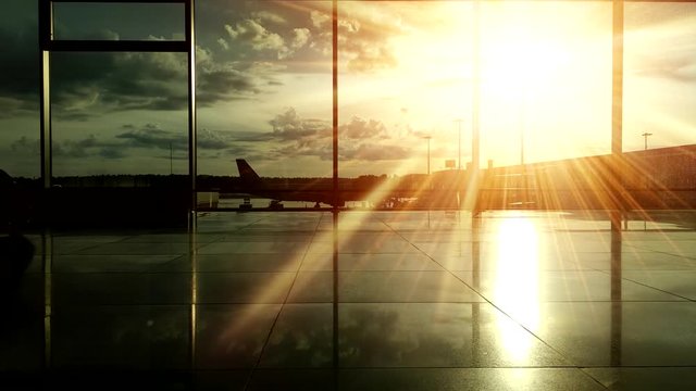 Silhouettes of passengers at the airport during sunset.
