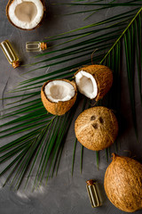 Coconut background with oil on grey background top-down