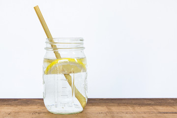 Lemon water and bamboo drinking straw.