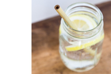 Lemon water and bamboo drinking straw.