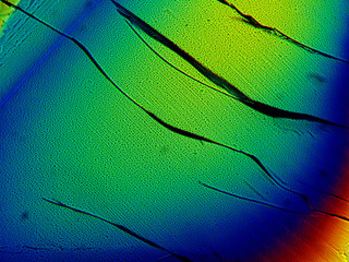 Crystal layer on microscope object glass, seen in polarized light. This causes random unforeseeable...