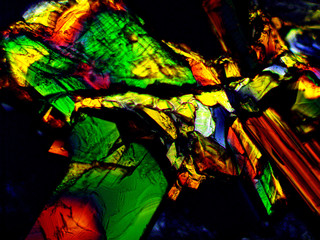 Crystal layer on microscope object glass, seen in polarized light. This causes random unforeseeable color effects.