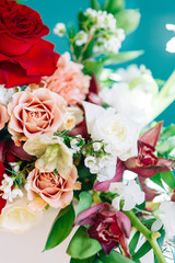 Decor of a stylish wedding ceremony. The decoration of the arch with red roses and wedding floristry. Modern trends in wedding bouquets.
