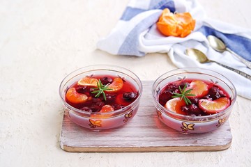 Dessert, sweet fruit jelly with cherries and tangerines in portioned bowls on a concrete background. Lenten desserts. Desserts without baking
