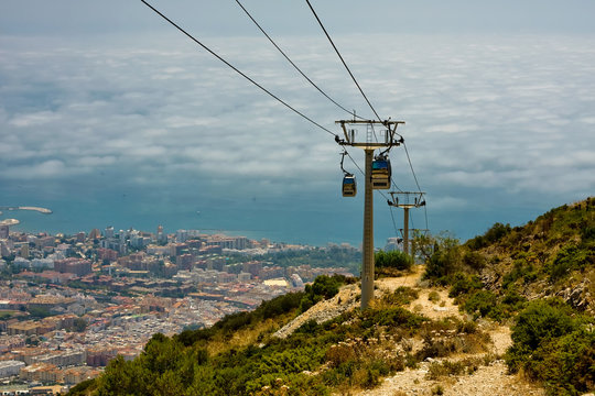 Cableway, poles, mountains, city at the foot