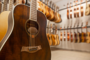 Close up of modern, wood guitar, view to instrument shop, music instrumental concept