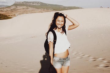 Portret van een vrouw in een warme broek die lacht op het strand van Bolonia