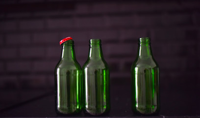 green glass bottles on a black background